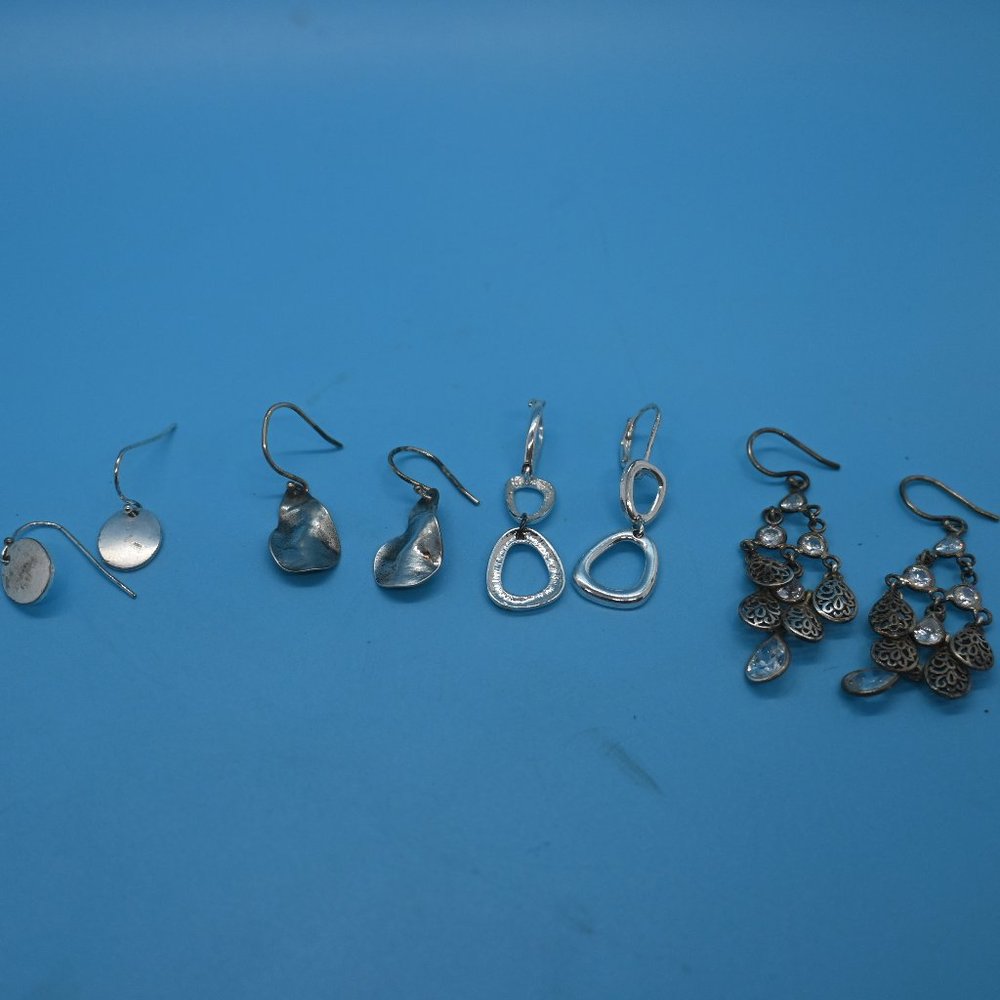 Four sets of silver pierced earrings.